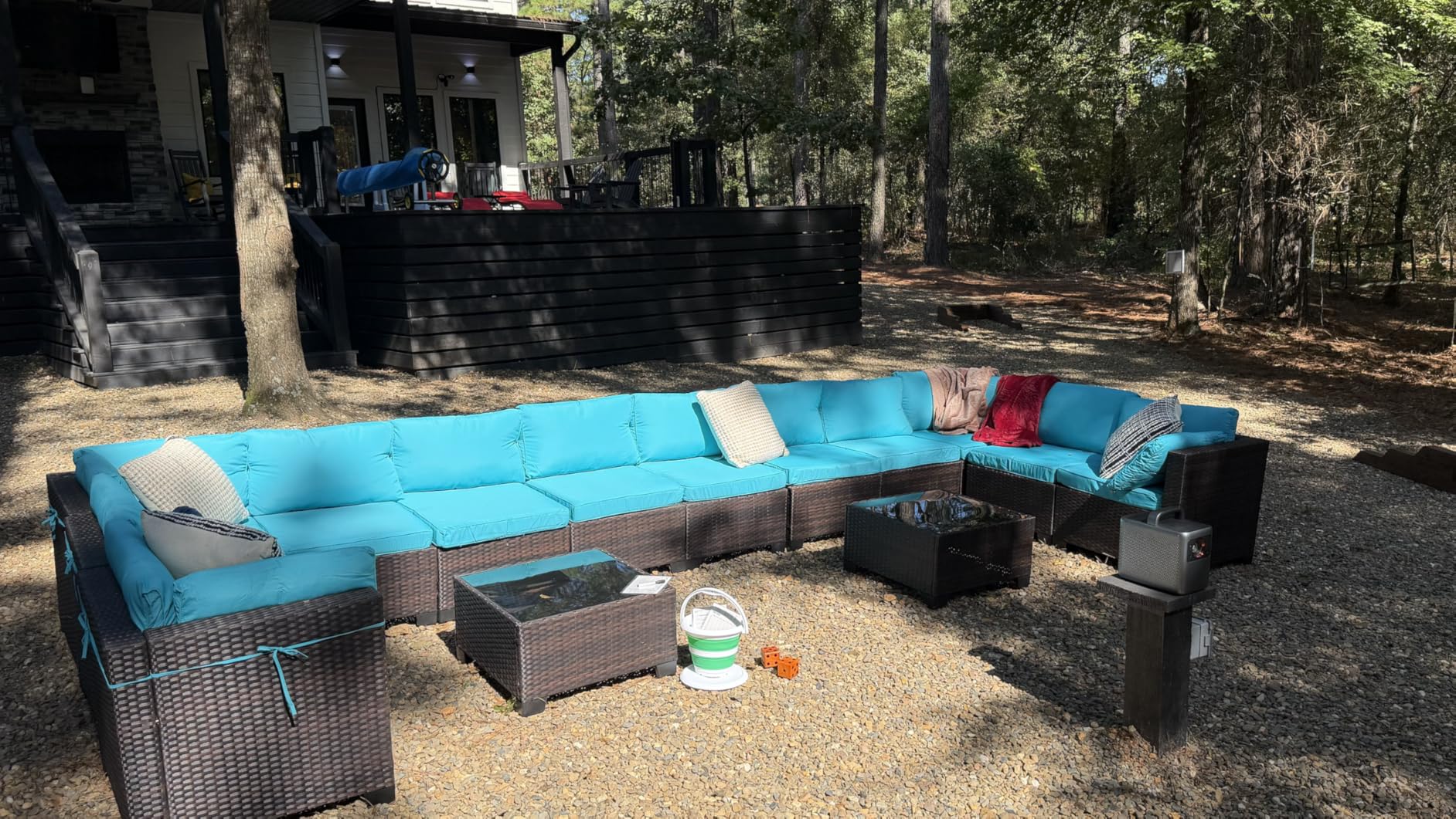 Backyard patio with a blue outdoor sectional and a yard dice bucket on the coffee table